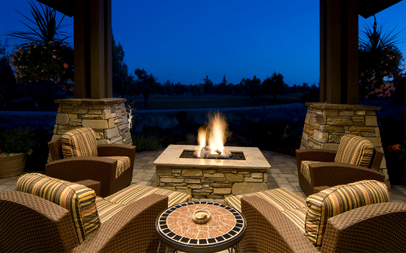 backyard patio at night time with fire pit lit