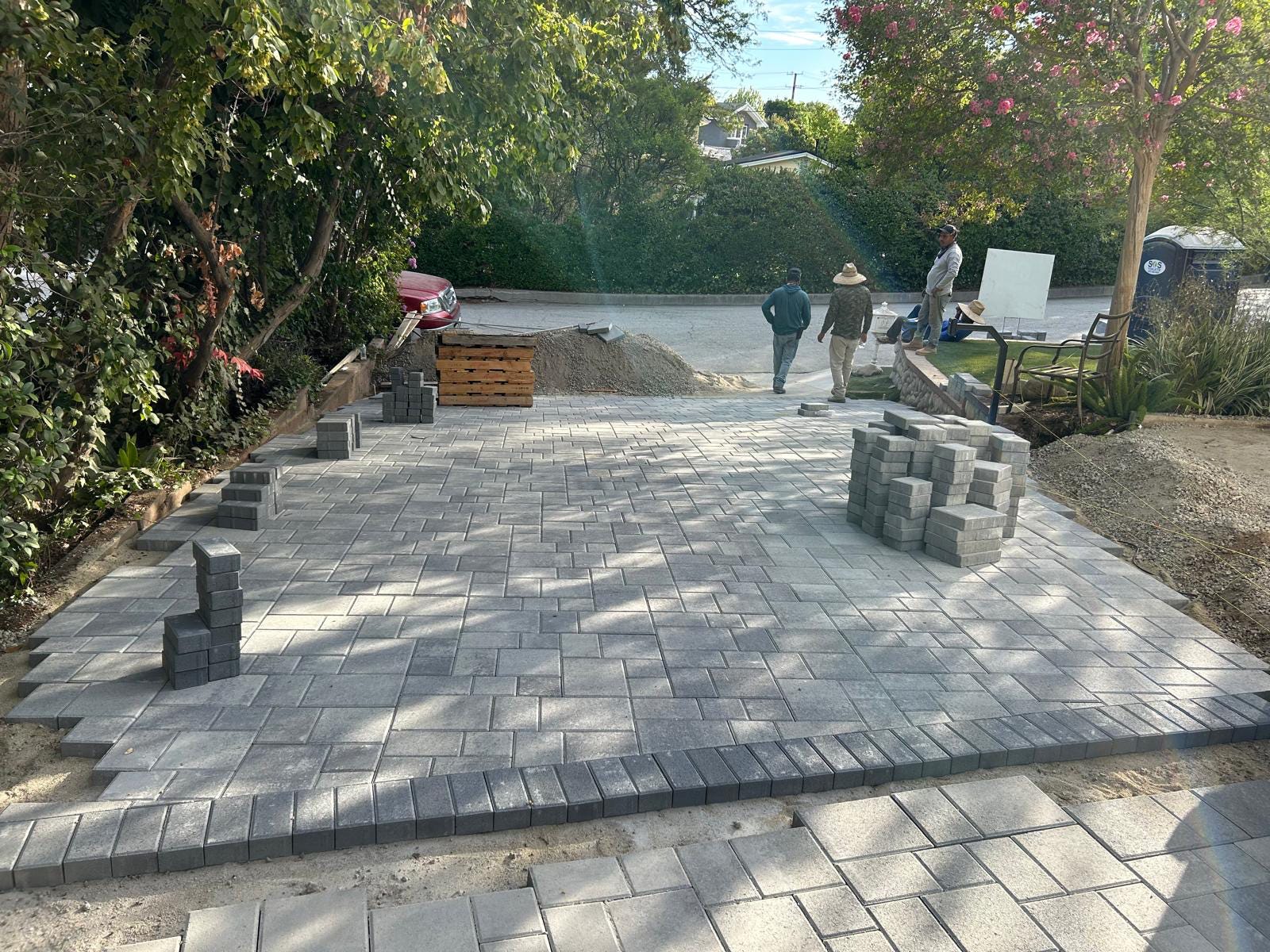Workers laying concrete pavers in Los Angeles Driveway