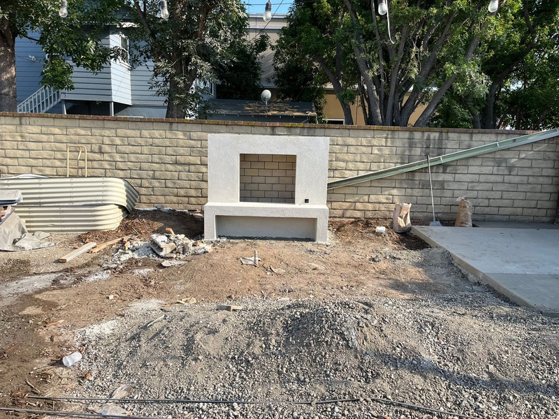 Smooth stucco finish applied to custom outdoor fireplace in Orange California backyard project