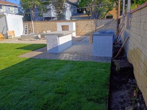 Completed backyard remodeling project in Orange, CA with pavers, Trex stairs, custom BBQ, fireplace, turf, fencing, and planters.