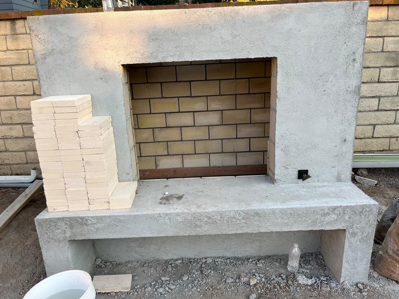 Custom outdoor fireplace with firebrick installation and smooth stucco preparation in Orange CA
