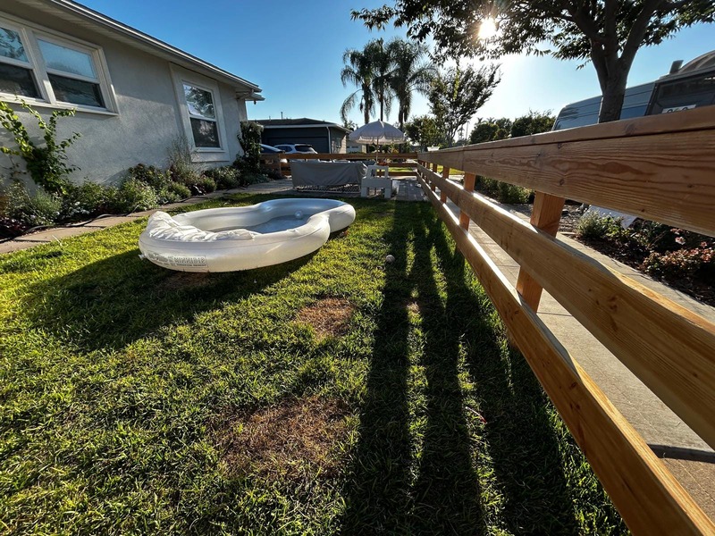 Custom wood fence surrounding front yard lawn and outdoor living space in Orange California