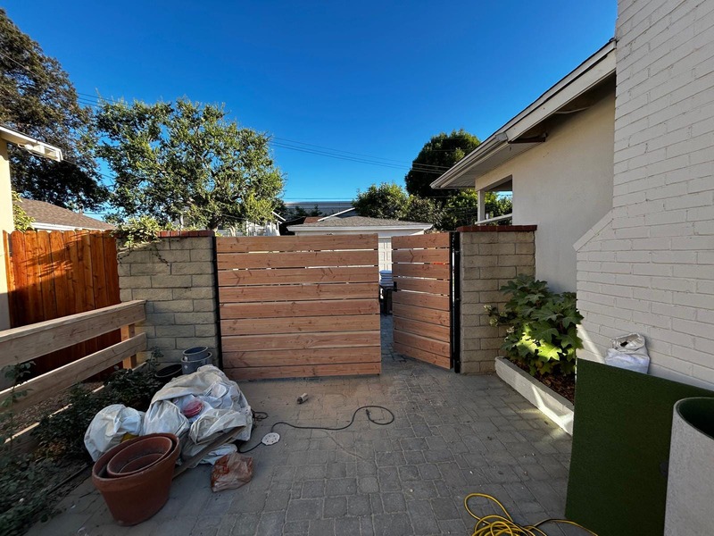 Custom horizontal wood side yard gate installation with black steel frame in Orange California