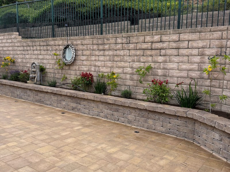 Small backyard paver patio and retaining wall remodel with custom hardscape and landscape construction.