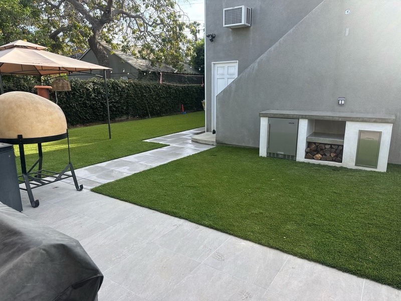 Finished backyard with artificial turf, porcelain patio, and custom outdoor kitchen in Los Angeles