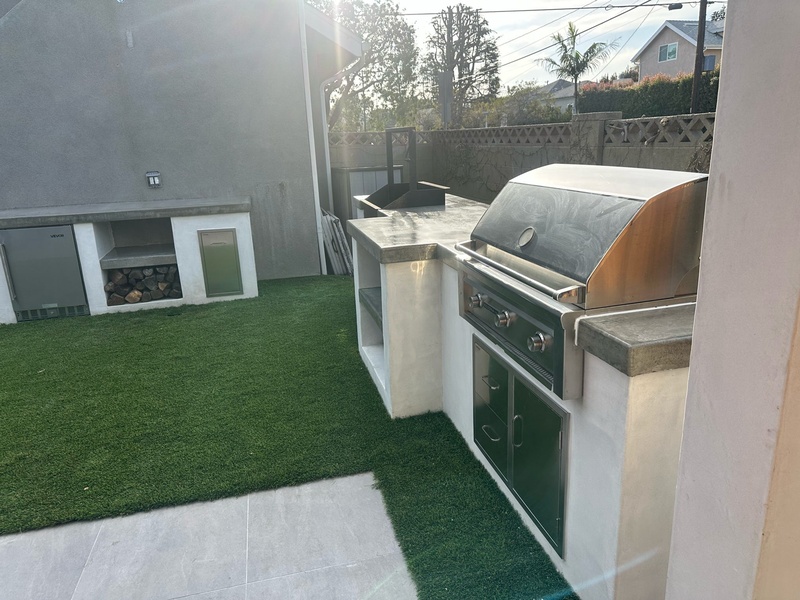 Finished BBQ island with built-in grill, pizza oven, and concrete countertops