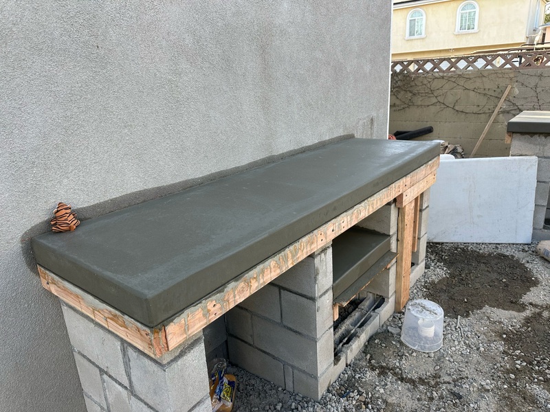 Concrete countertop installation during custom outdoor kitchen construction